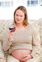 Pregnant woman looking at a glass of red wine
