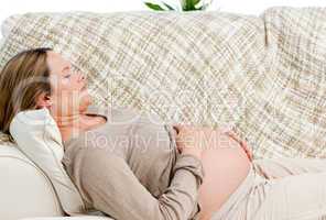 Tired pregnant woman relaxing on her sofa