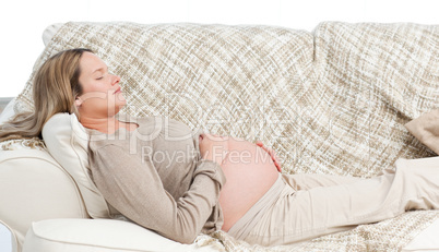 Asleep pregnant woman lying on the sofa
