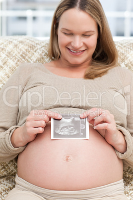 Adorable woman showing an echography to the camera