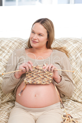 Future mother knitting and looking the side