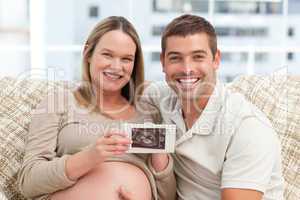 Joyful future parents looking at an echography together