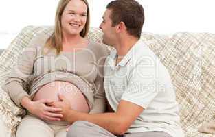 Happy man touching the belly of his pregnant wife