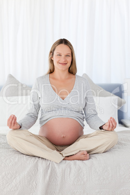 Pretty pregnant woman doing yoga