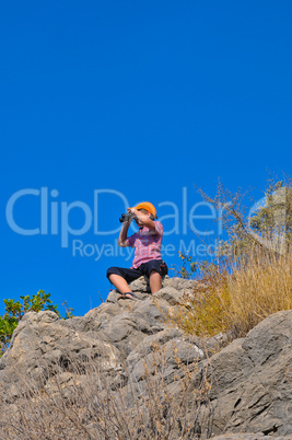 The boy with the glasses on the rocks