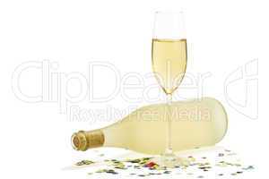 ein glass mit champagner vor einer flasche prosecco mit konfetti