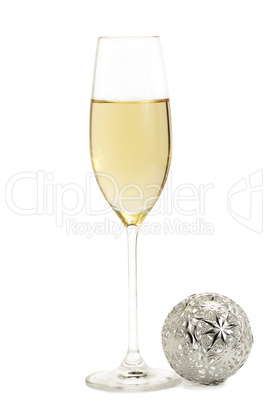 ein glas mit champagner mit einer metallenen christbaumkugel