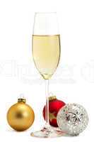 ein glas mit champagner mit einer roten, goldenen und metallenen christbaumkugel
