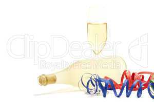 ein glas mit champagner mit luftschlangen vor einer liegenden flasche mit prosecco
