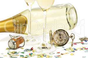 zwei sektgläser mit alter taschenuhr, einem champagnerkorken und konfetti vor einer sektflasche