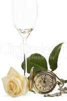 eine cremefarbene rose mit einer alten taschenuhr und einem leeren sektglas