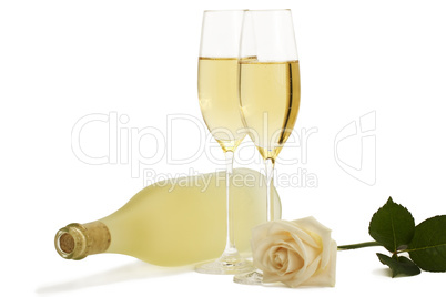 eine cremefarbene rose mit zwei sektgläsern und einer liegenden flasche prosecco