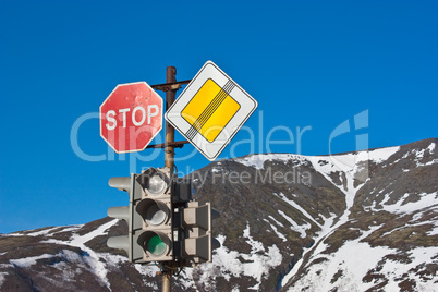 Stop! Road signs and traffic light on blue sky