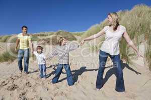 Mother, Father and Two Boys Holding Hands At Beach