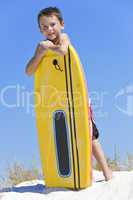 Young Boy Child With Surfboard At The Beach