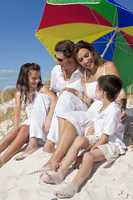 Family Laughing Under Colorful Umbrella On Beach