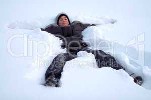 Happy Boy Laying In Fresh Snow