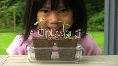 Little Asian Girl Admiring Her Plants
