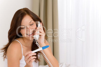 Pregnancy test - happy woman on phone