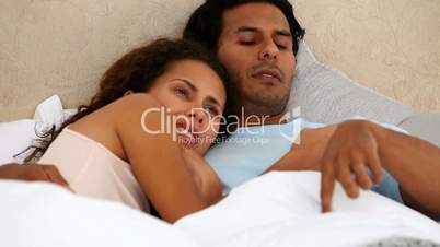 Paar liegt im Bett und redet