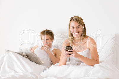 Young couple relax in bed listen to music