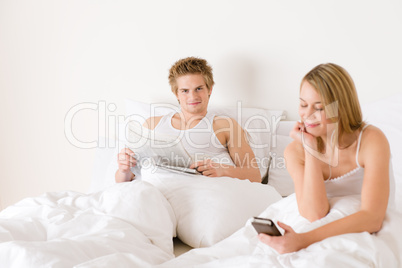 Young couple relax in bed listen to music