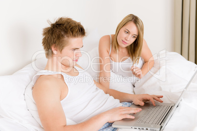 Bedroom - young couple with laptop and book