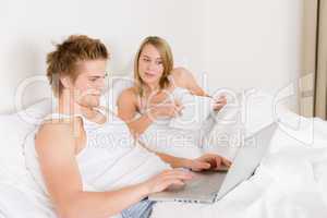 Bedroom - young couple with laptop and book