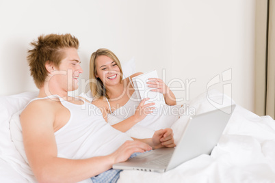 Bedroom - young couple with laptop and book