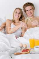 Luxury hotel honeymoon breakfast - couple in bed