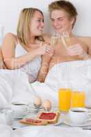 Luxury hotel honeymoon breakfast - couple in bed