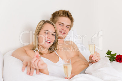 Engagement ring - couple in bed with champagne