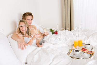 Luxury hotel honeymoon breakfast - couple in bed