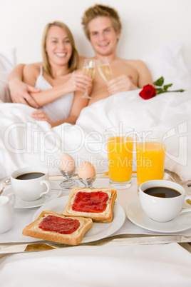 Luxury hotel honeymoon breakfast - couple in bed