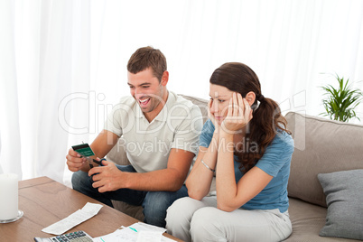Happy man cutting his credit card with scissors with his girlfri