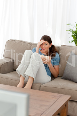 Beautiful woman watching a horror movie on television