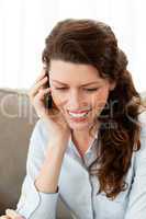 Smiling businesswoman on the phone while resting on the sofa
