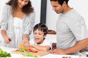 Happy family preparing a salad together in the kitchen