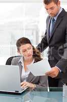 Handsome manager showing a paper to a businesswoman while workin