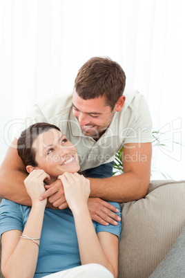 Affectionate man talking with his girlfriend sitting on the sofa