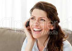Joyful woman on the phone sitting on the sofa