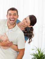 Joyful couple laughing topgether in the living-room