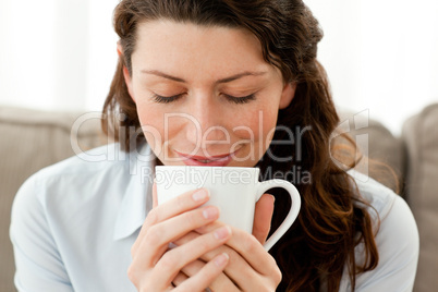 Cute businesswoman enjoying her coffee at home