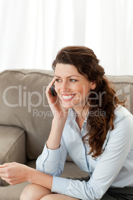 Cheerful businesswoman on the phone sitting on the sofa