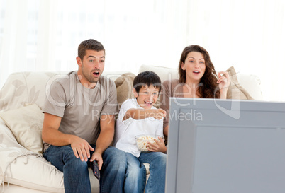 Happy family watching a movie on television together on the sofa
