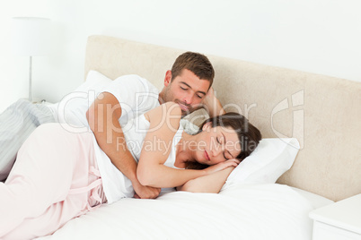 Passionate man looking at his girlfriend sleeping peacefully