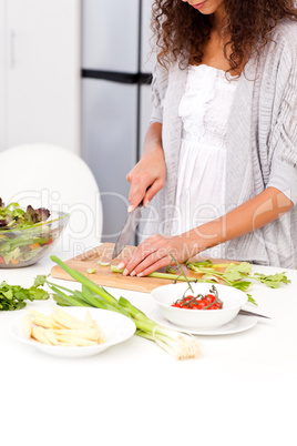 Close up of a woman cutting vegetables in the kitchen