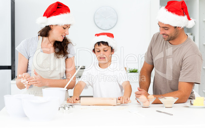 Proud parents looking at their son using a rolling pin