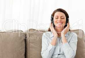 Happy businesswoman listening music with headphones