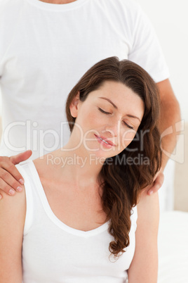Attentive man massaging his girlfriend's back sitting on their b